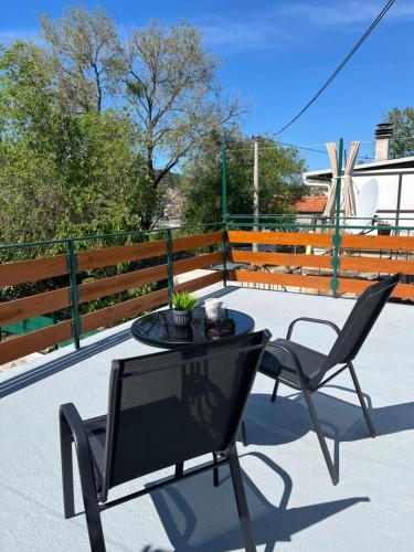a patio with a table and chairs and a fence at The Nook in Bilice