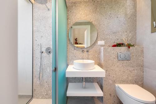 a bathroom with a sink and a toilet and a mirror at Levanda apart in Dassia