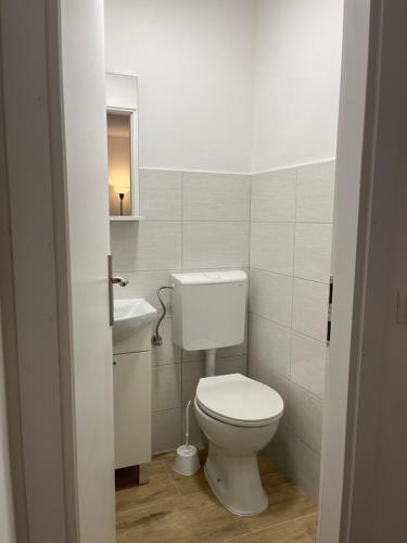 a white bathroom with a toilet and a sink at The Nook in Bilice