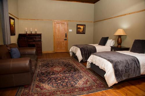 a hotel room with two beds and a couch at Grootvallei Guest Farm - Main lodge in Boshof