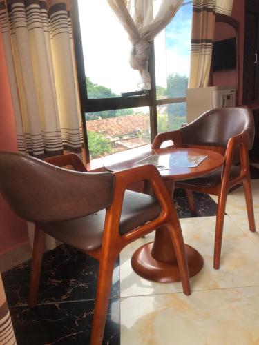 タンガにあるDespacito Hotelの窓際の椅子2脚とテーブル