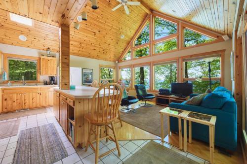 a living room with a blue couch and a kitchen at Gebhard Chalet - Charming, private, beachfront chalet nestled in a wooded dune on Lake Michigan in Coloma