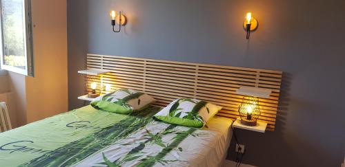 um quarto com uma cama com duas almofadas verdes em Villa Mas Fa Susa 3 étoiles avec piscine em Les Vans