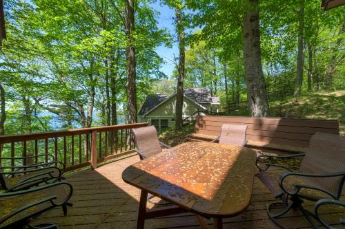 a patio with a table and chairs on a deck at Gebhard Chalet - Charming, private, beachfront chalet nestled in a wooded dune on Lake Michigan in Coloma