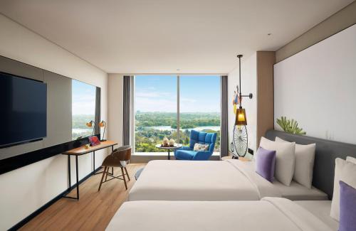 a hotel room with a bed and a flat screen tv at Hyatt Centric Hebbal Bengaluru in Bengaluru