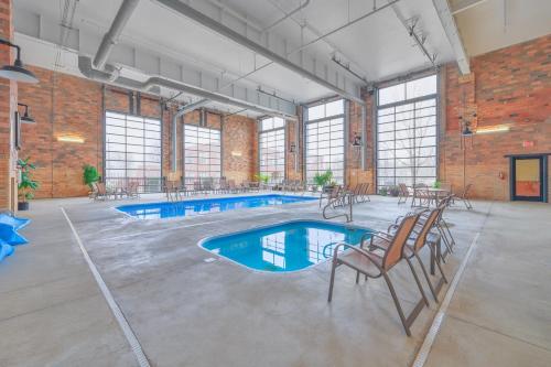 a large room with two swimming pools and chairs at Ground Floor Getaway- Year round pool and hot tub in South Haven