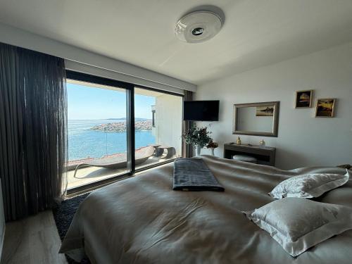 a bedroom with a large bed with a large window at Villa Night Pearl in Trogir
