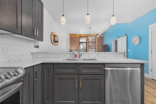 a kitchen with gray cabinets and a sink at Ground Floor Getaway- Year round pool and hot tub in South Haven