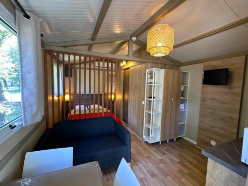 a living room with a blue couch and a window at Camping Dolce Vita in Calvi