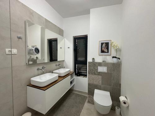 a white bathroom with a sink and a toilet at Villa Night Pearl in Trogir