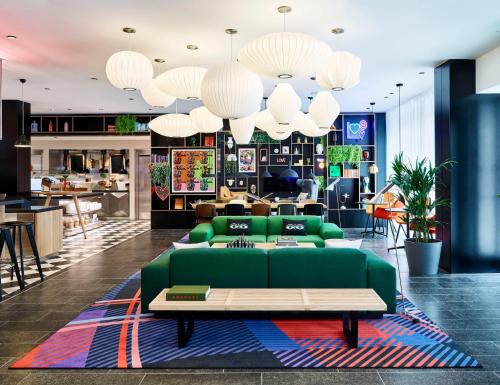 a living room with a green couch and a table at citizenM Boston Back Bay in Boston