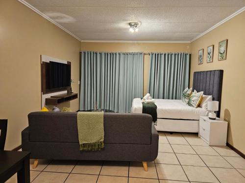 a living room with a couch and a bed at Grace Haven in Sandton
