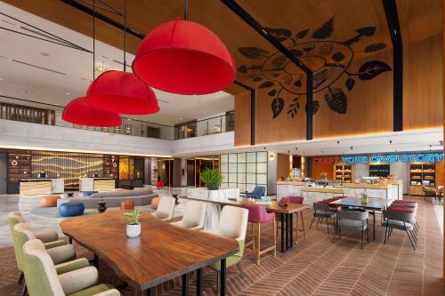 a lobby with tables and chairs and a restaurant at Hyatt Centric Hebbal Bengaluru in Bengaluru