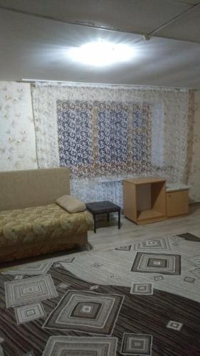 sala de estar con sofá y alfombra en Гостевой дом ОЛЖАС en Borovoye