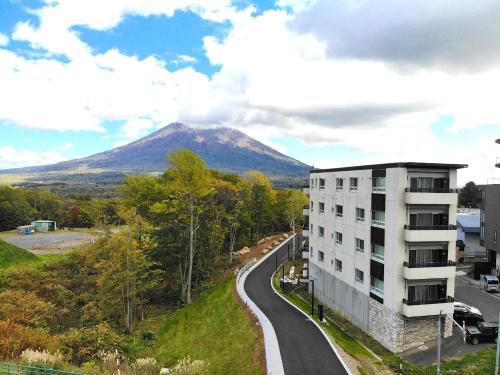a building and a road with a mountain in the background at The Freshwater in Kutchan