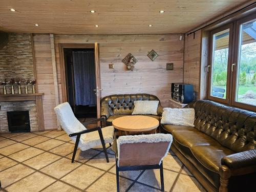 a living room with a couch and a table at Holiday House & Sauna in Druskininkai in Neravai