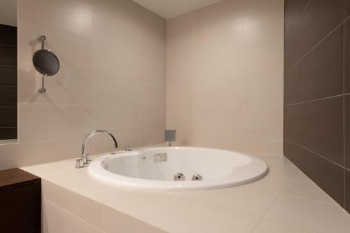 a white bathroom with a bath tub in it at The Freshwater in Kutchan