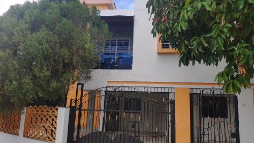 ein weißes Gebäude mit einem Tor und einem Baum in der Unterkunft Sol nacer in Santo Domingo