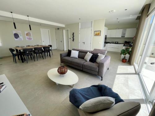 a living room with a couch and a table at Bugibba Square Seafront LUX Apartments by Holi in St Paul's Bay