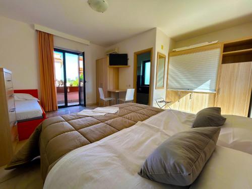 a hotel room with two beds and a television at Resort Park Village in Rossano