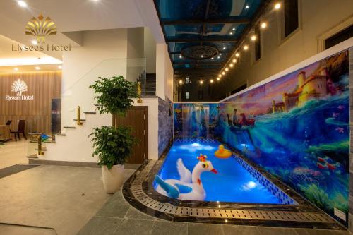 a large indoor pool in a building with a water slide at Elysees Sam Son Beach Hotel in Thanh Hóa
