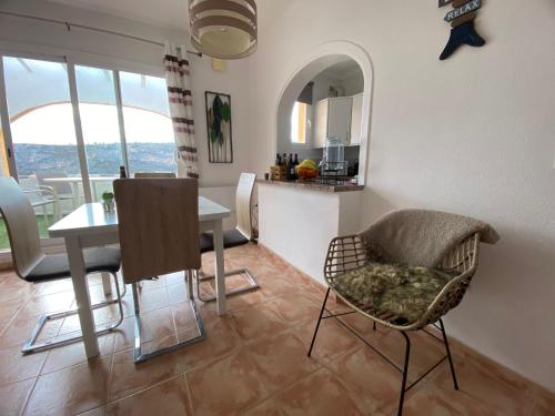 - une cuisine et une salle à manger avec une table et des chaises dans l'établissement Apartment Casa Lieja - Cumbre del Sol, à Cumbre del Sol