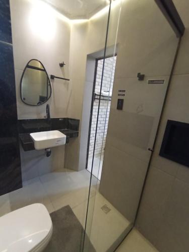 a bathroom with a toilet and a sink and a shower at Praia do Bessa, Caribessa - Quarto Privativo - Conforto, Paz e Sossego, excelente para descansar, trabalhar ou estudar in João Pessoa