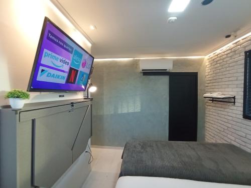 a room with a flat screen tv on top of a bed at Praia do Bessa, Caribessa - Quarto Privativo - Conforto, Paz e Sossego, excelente para descansar, trabalhar ou estudar in João Pessoa
