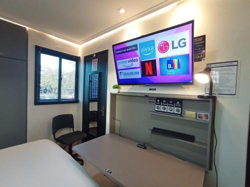a room with a bed and a flat screen tv at Praia do Bessa, Caribessa - Quarto Privativo - Conforto, Paz e Sossego, excelente para descansar, trabalhar ou estudar in João Pessoa