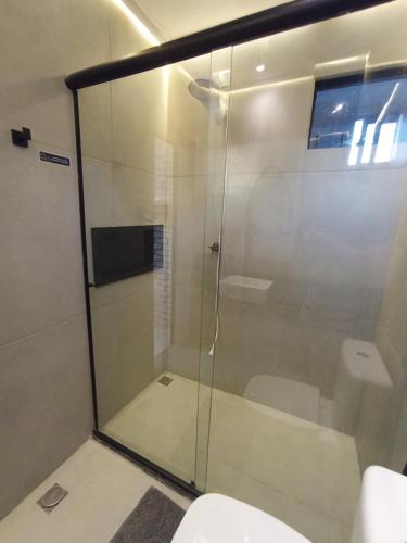 a glass shower in a bathroom with a toilet at Praia do Bessa, Caribessa - Quarto Privativo - Conforto, Paz e Sossego, excelente para descansar, trabalhar ou estudar in João Pessoa