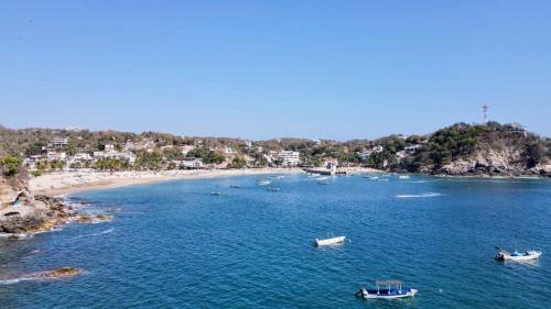 an aerial view of a beach with boats in the water at Casa Mamá Lolis in Puerto Ángel