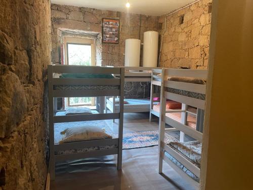 Zimmer mit Etagenbetten in einer Steinwand in der Unterkunft Au village in Serriera