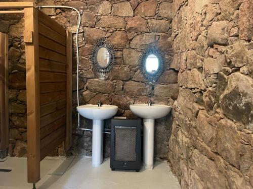 ein Badezimmer mit zwei Waschbecken in einer Steinwand in der Unterkunft Au village in Serriera