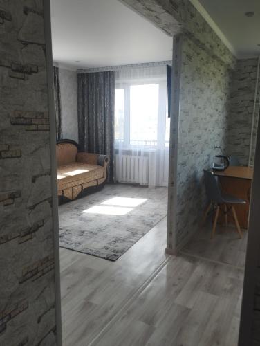 una puerta abierta a una sala de estar con sofá y escritorio en Квартира, en Baljash