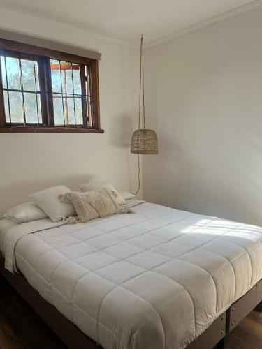 a large white bed in a room with a window at La Posada Coliving in Viña del Mar