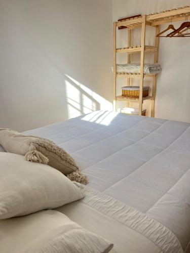 a white bed with pillows and a ladder in a room at La Posada Coliving in Viña del Mar