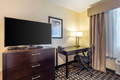 a hotel room with a desk and a flat screen tv at Best Western Plus Edmonds Harbor Inn in Edmonds