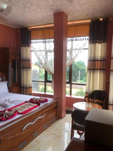 a bedroom with a bed and a large window at Despacito Hotel in Tanga