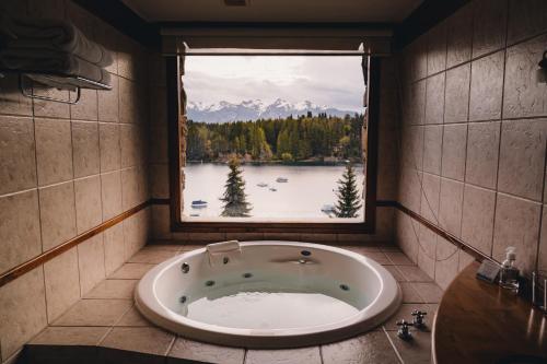 a bath tub in a bathroom with a large window at Marinas Alto Manzano in Villa La Angostura
