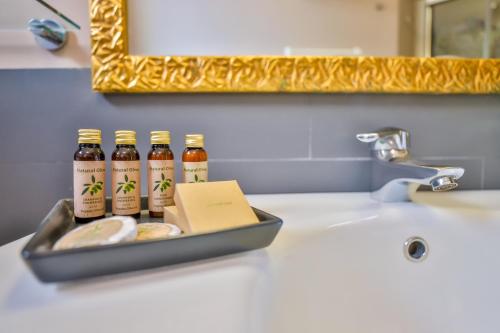 un vassoio di bottiglie di birra seduta su un lavandino del bagno di Villa Santa Maria - Luxury Sea View Rooms ad Amalfi