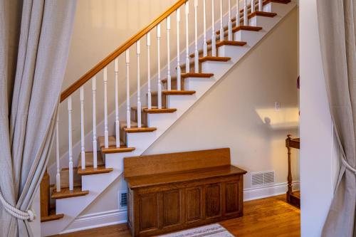 a staircase with wooden treads and a wooden cabinet in a house at For Pete's Sake - private pickleball court & 2 blocks to beach! in South Haven