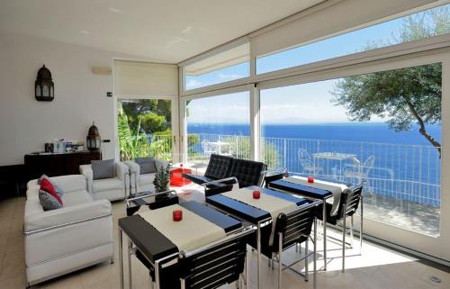 a living room with a table and chairs and a large window at Villa Santa Maria - Luxury Suites in Amalfi