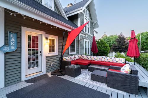 a patio with a red couch on a house at For Pete's Sake - private pickleball court & 2 blocks to beach! in South Haven
