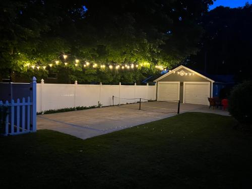a backyard at night with a fence and a tennis court at For Pete's Sake - private pickleball court & 2 blocks to beach! in South Haven