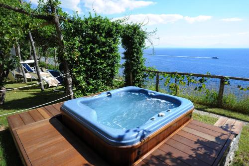 a hot tub sitting on a deck next to the ocean at Villa Santa Maria - Luxury Suites in Amalfi