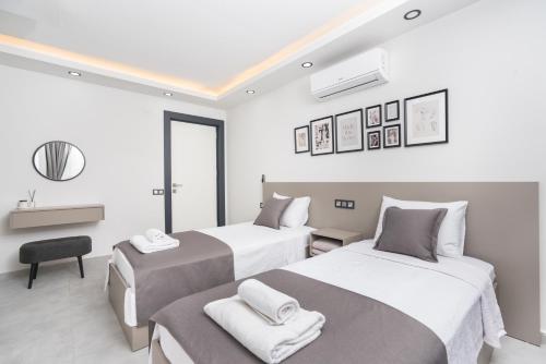 two beds in a room with white and gray at Villa Heri in Kas