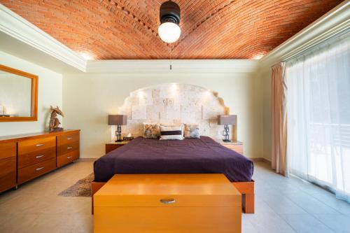 a bedroom with a large bed with a brick ceiling at Villa Pura Vida - Spacious Oceanview with private pool - At Playacar Phase I in Playa del Carmen