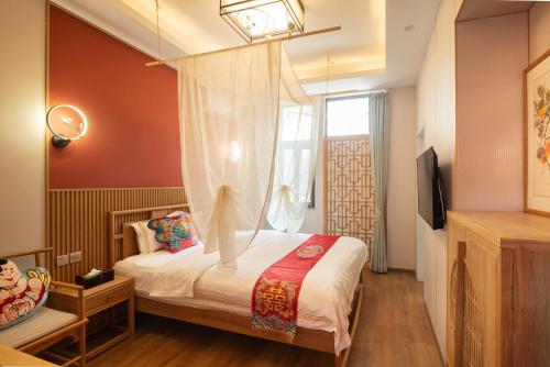 a bedroom with a canopy bed with a window at Rong Hotel - Beijing Nanluoguxiang Branch in Beijing