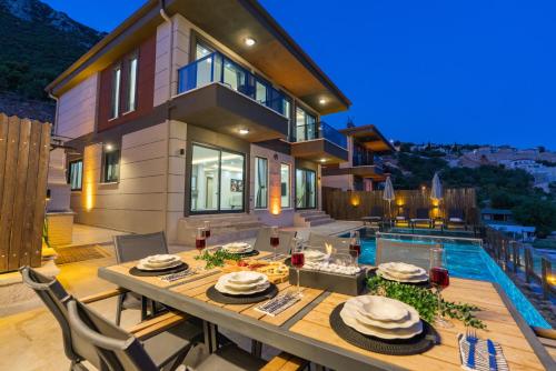 a house with a dining table and a pool at Villa Heri in Kas