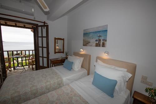 una camera da letto con due letti e vista sull'oceano di Lilian Beach Front 3 Skopelos a Panormos Skopelos